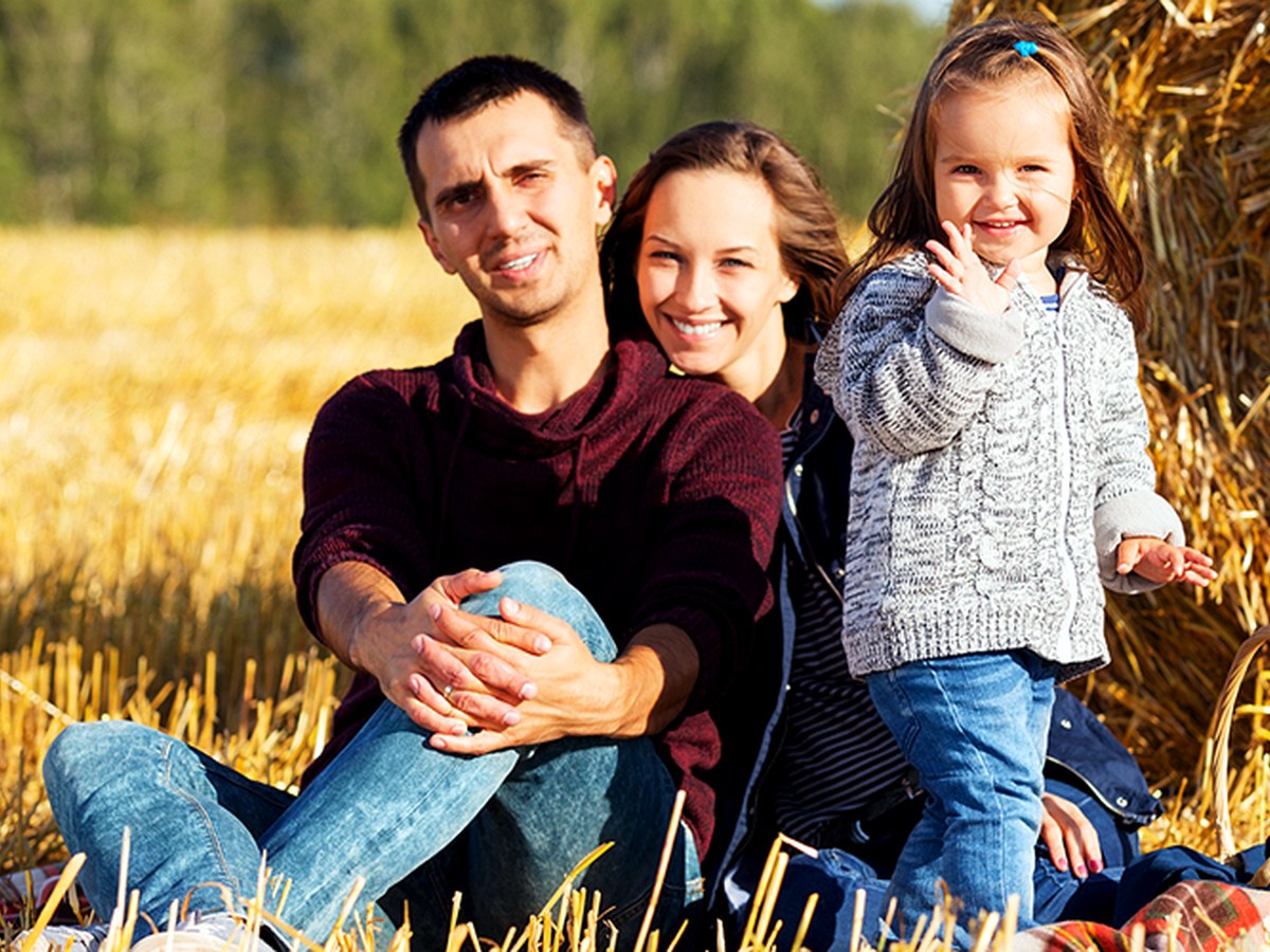 A family in a harvested Wisconsin wheat field at golden hour